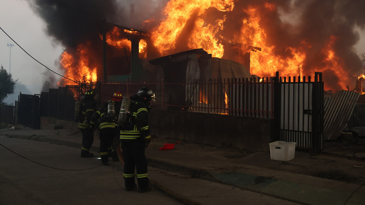 Bomberos apagando incendio en Penco.